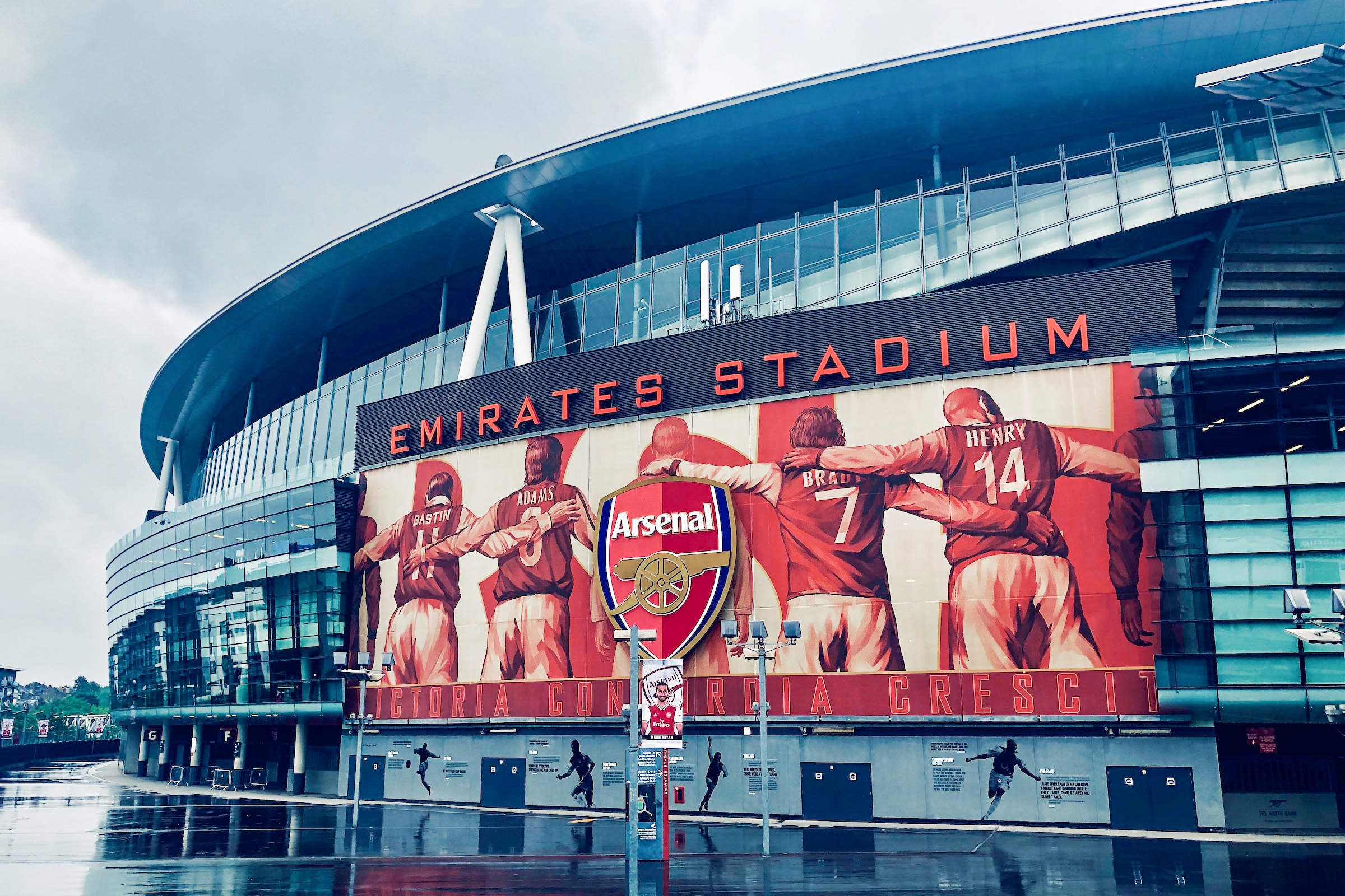 Arsenal FC Emirates Stadium entrance with fans gathering outside.